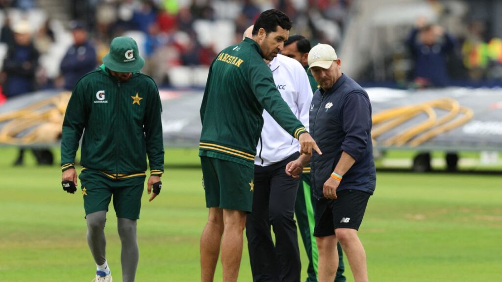 Pakistan bowling coach Umar Gul points out a wet spot on the pitch during a rain delay in the first Test against England at Headingley